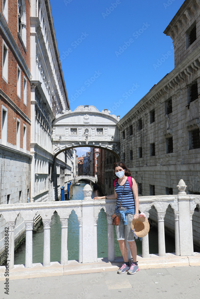 young woman with straw hat on the bridge in Venice in Northern Italy in Europe