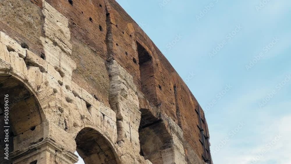 Panning shot of beautiful ancient italian sandstone Colosseum in Rome during sunny day Panning shot of beautiful ancient italian sandstone Colosseum in Rome during sunny day