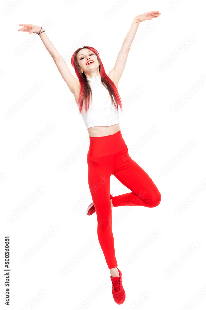 A beautiful, athletic, slender, smiling and cheerful woman in a white top and red sweatpants performs pragues. Dance, jump. Lifestyle concept with sports and gym, healthy lifestyle. Isolated on white