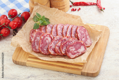 Sliced salami sausages over board