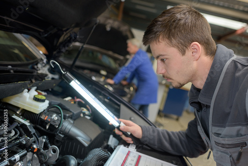 student with instructor repairing a car during apprenticeship © auremar