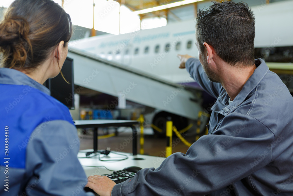 two modern aircraft engineers pointing an airplane two modern aircraft engineers pointing an airplane