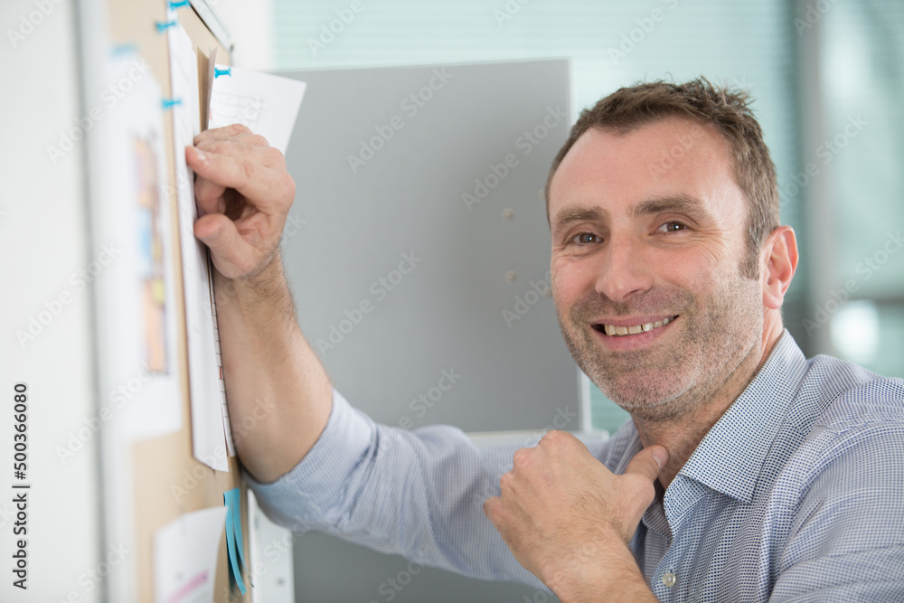 Obraz premium mid-adult man looking at notice board