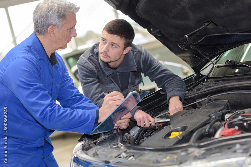 apprentice automotive mechanic and professor at work apprentice automotive mechanic and professor at work