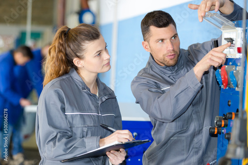 technician showing electrical switches to apprentice