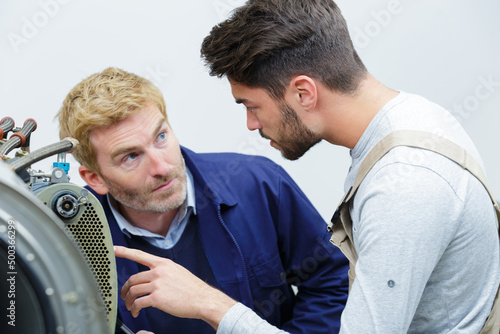 portrait of men inspecting mechanical parts