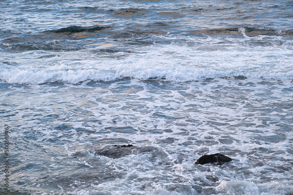 Obraz premium Pastel-gray sea. texture of a raging ocean, full frame with space for text. The concept of weather, vacation, travel. The purest clear sea water, big waves close-up. Calm natural light gray background