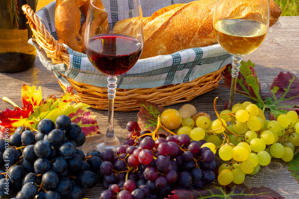 Symbolbild: Reife Weintrauben mit Weingläsern dekoriert auf einem Holztisch