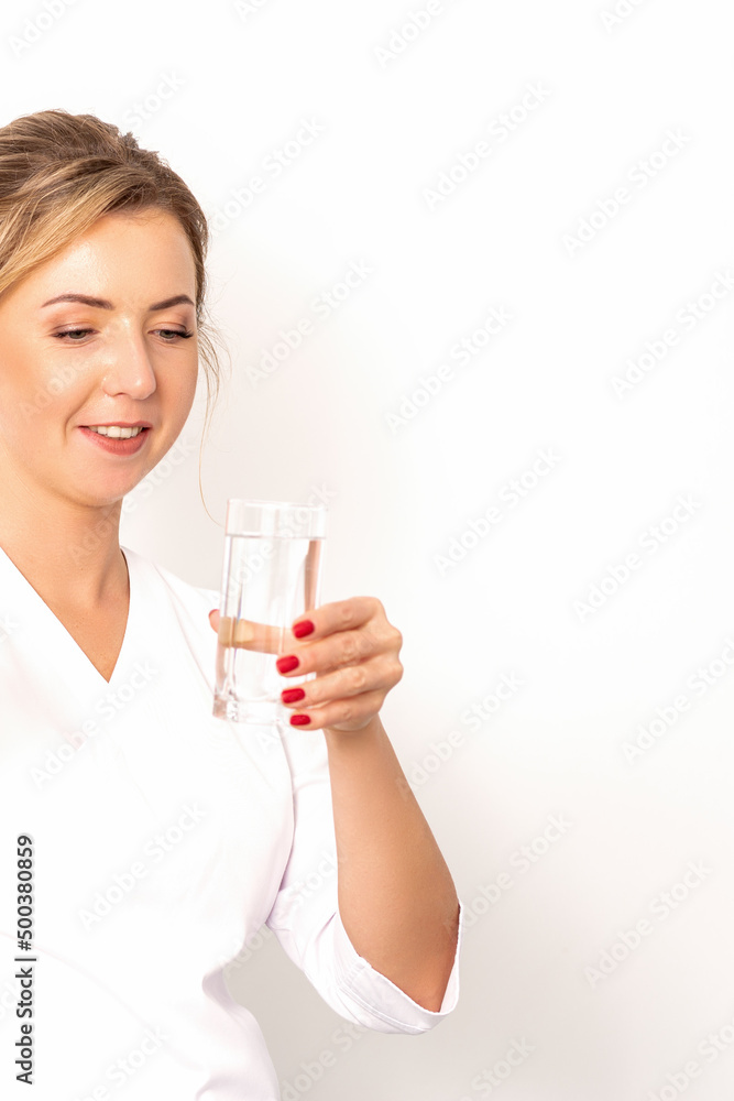 A glass of water. The female nutritionist holds a glass of water in her hand on white background A glass of water. The female nutritionist holds a glass of water in her hand on white background