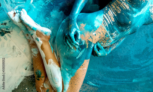 expressive sexy body part, hands and feet of a young woman, painted in turquoise, blue color, in the studio, modern abstract bodypainting photo