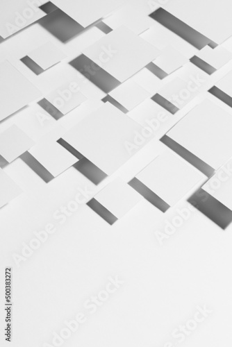 White geometric abstract background with rhombuses in hard light with strict gradient contrast dark shadows as border, copy space, top view, vertical. Simple contemporary backdrop in future style.