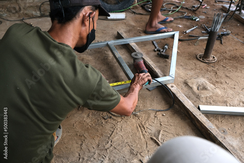 A man works as a welder in a local repair shop
