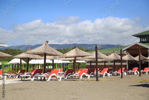 Beach with umbrellas and sun loungers by the sea on a sunny day, Montenegro. © ksi