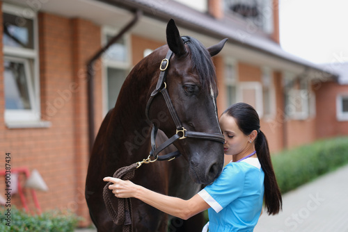 Woman veterinarian conducts medical examination of sports horse © H_Ko