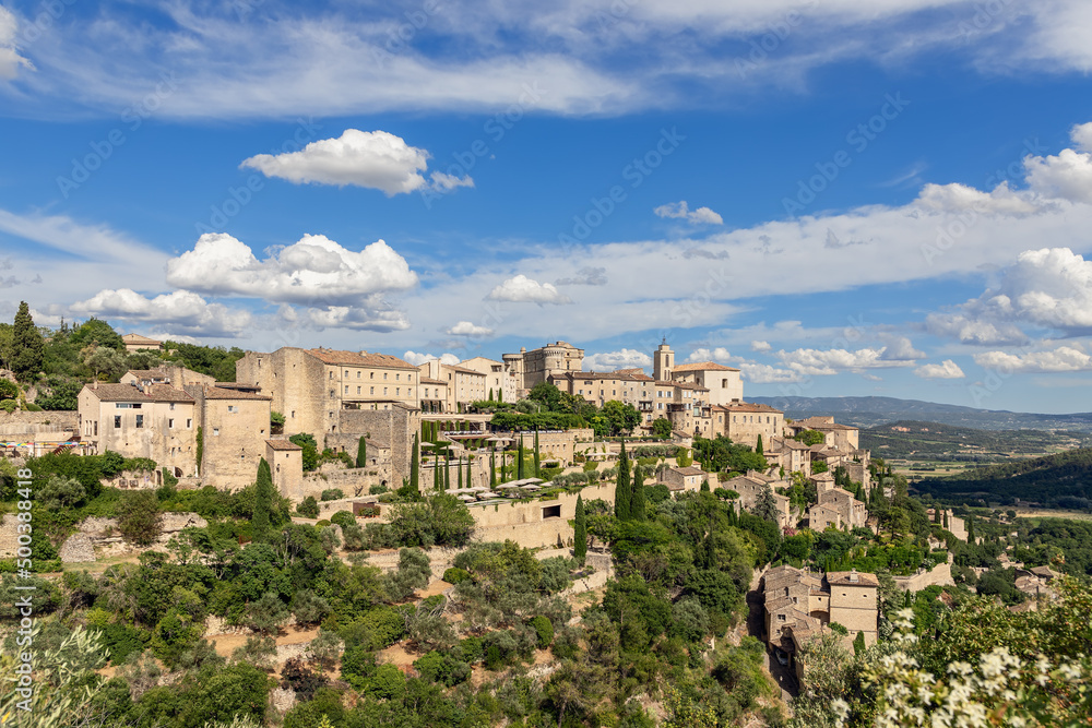 Green calcareous rock and antique tiny village of same name Gordes on prominent point over Luberon valley. Vaucluse, Provence, Alpes, Cote d'Azur, France