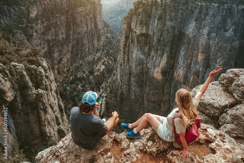 Couple hiking together sitting on cliff edge travel healthy lifestyle active vacations outdoor man and woman enjoying Tazi canyon aerial view in Turkey