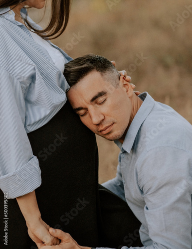 Pregnant girl with her husband tenderly embrace