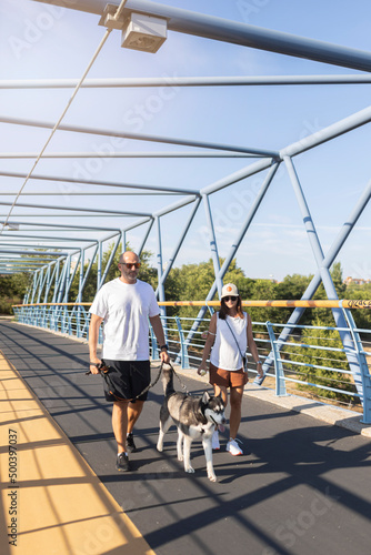 Couple with dog walking on footbridge