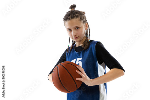 Portrait of teen girl, basketball player in uniform posing isolated over white studio background. Concentration