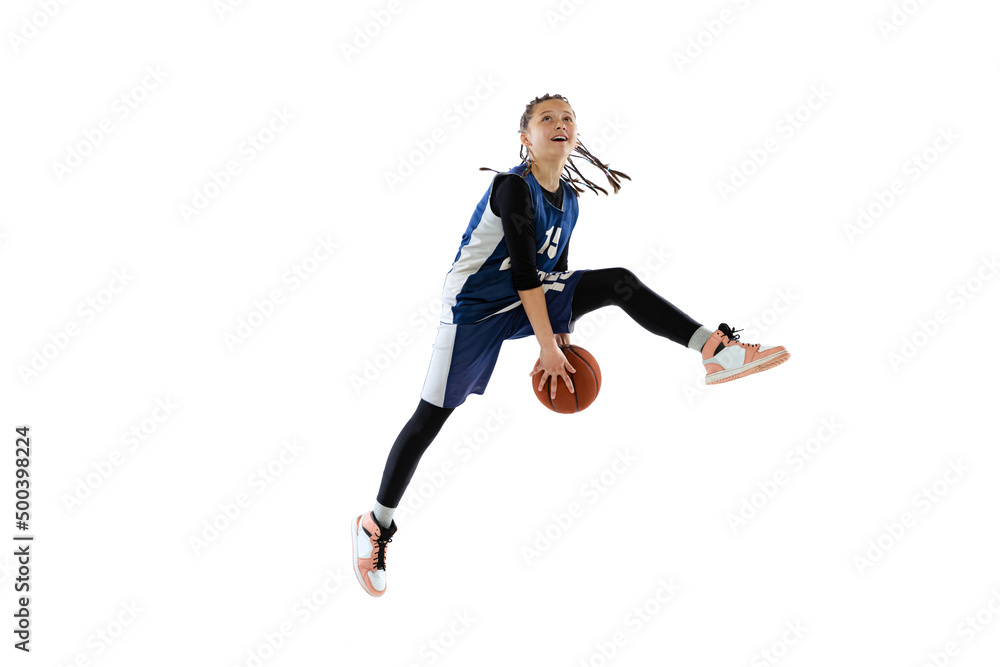 Dynamic portrait of teen girl, basketball player training, jumping with ball isolated over white studio background. Bounce pass