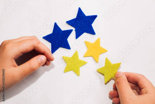 Application of felt stickers of stars in the colors of the blue-yellow Ukrainian flag.