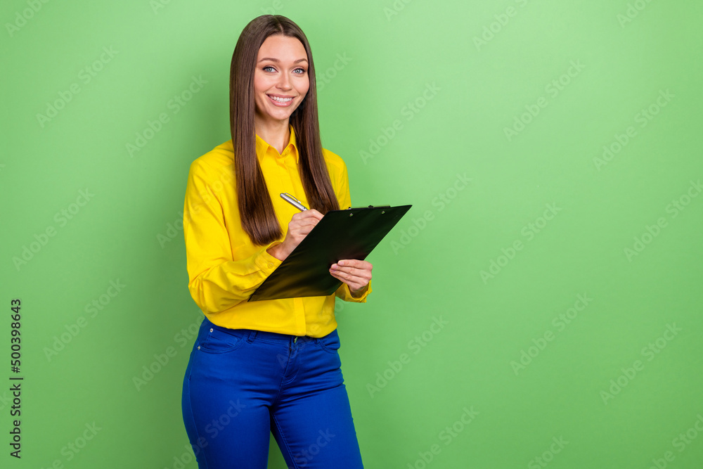 Portrait of attractive cheerful girl employee writing plan to-do list copy space isolated over green pastel color background Portrait of attractive cheerful girl employee writing plan to-do list copy space isolated over green pastel color background