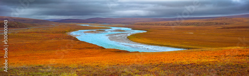 Panorama image of a tundra landscape in autumn colors with river and oil pipeline (Trans Alaska Pipeline), North Slope, Alaska photo
