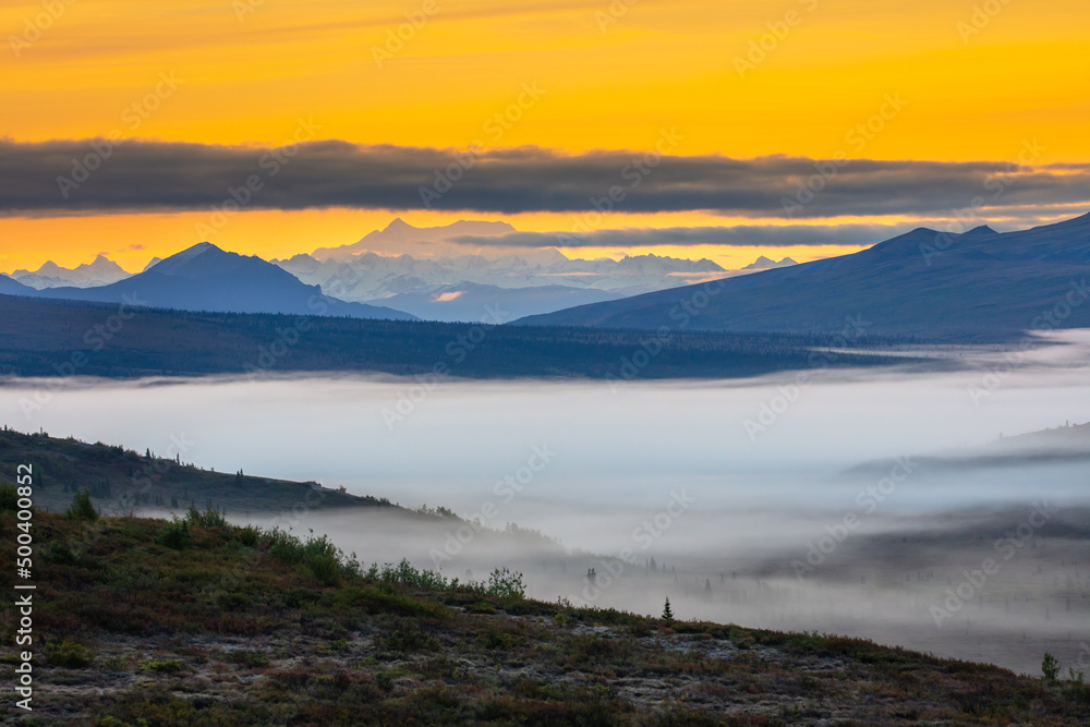 Sunrise in the mountains of Denali National Park, Alaska; autumn fog covers a valley