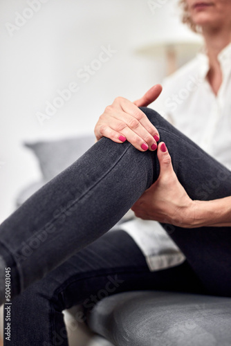 Woman with spasm  cramp  sprained  dislocated knee and joint pain  exercising at home.