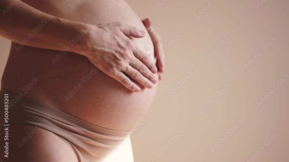 pregnant woman. health pregnancy motherhood procreation concept. close-up belly of a pregnant sunlight woman. woman waiting for a newborn baby. pregnant woman holding her belly indoors pregnant woman. health pregnancy motherhood procreation concept. close-up belly of a pregnant sunlight woman. woman waiting for a newborn baby. pregnant woman holding her belly indoors
