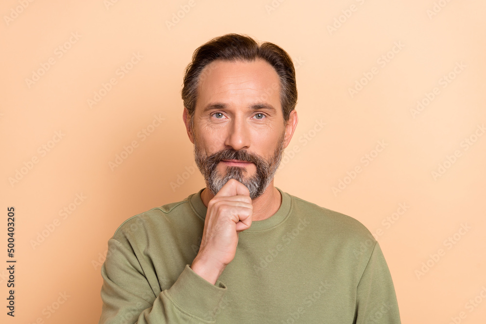 Photo of smart minded person arm on chin look camera isolated on pastel beige color background Photo of smart minded person arm on chin look camera isolated on pastel beige color background
