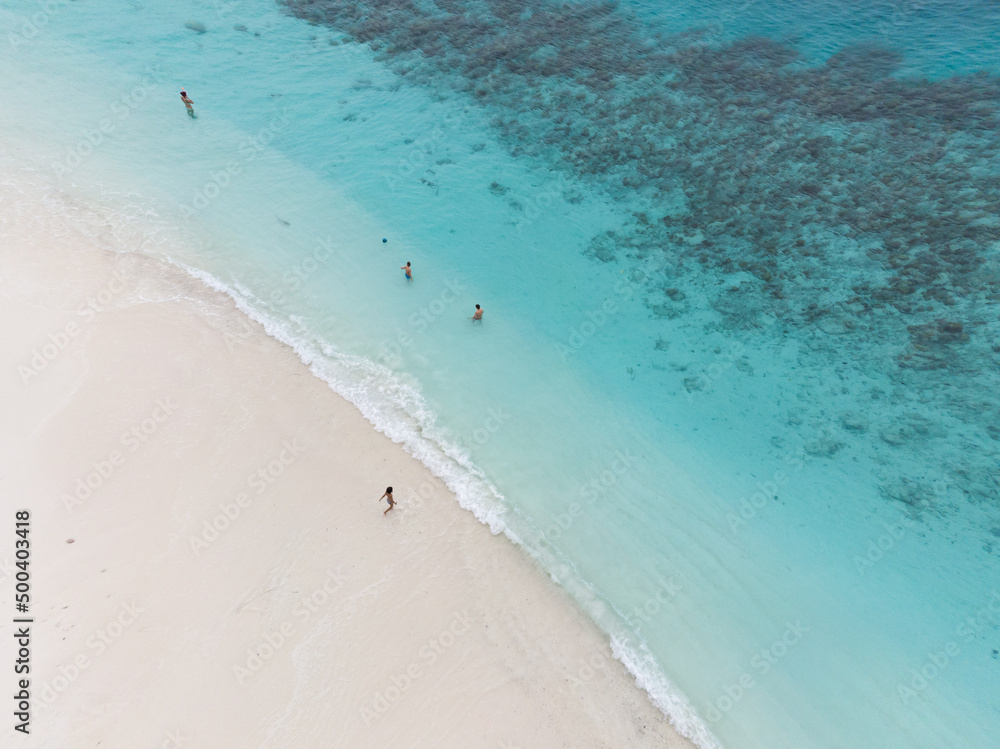 Top view of sunbathers on the beach in maldives 