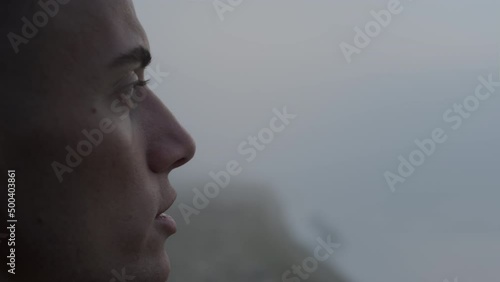 Dreamy man enjoying ocean landscape at sunrise. Calm guy talking with himself