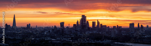 Panorama of the urban skyline of London during an intense sunset with City, river Thames and London bridge