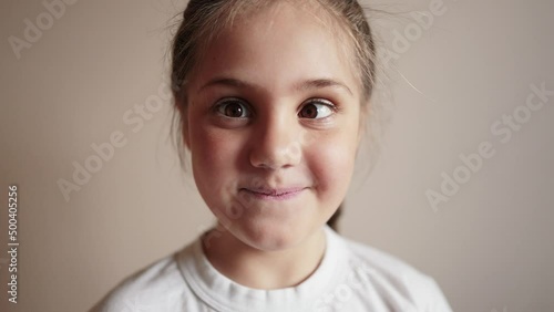 child girl playing funny a squinting eyes. strabismus squint happy family kid dream concept. daughter little girl having fun smiling twisting her eyes lifestyle funny content photo