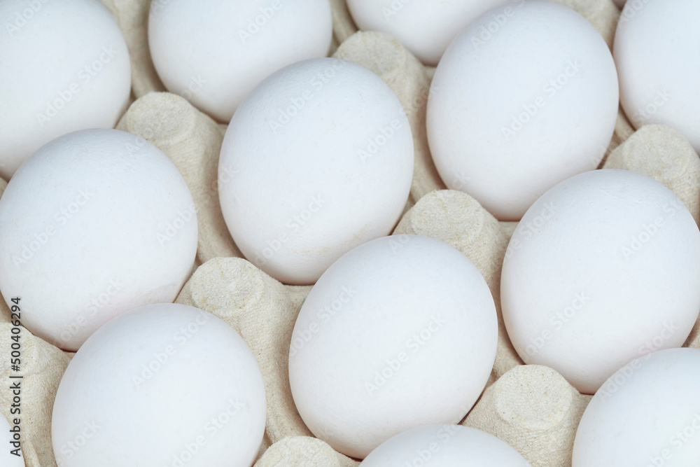 White eggs in recycled paper tray close-up. Selective focus White eggs in recycled paper tray close-up. Selective focus