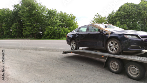 Damaged car on a tow truck. Car towing service. Broke auto concept background. Automobile insurance.