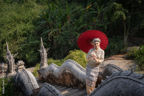 Beautiful Asian women dressed in traditional costumes visit Wat Palad or Wat Pha Lat temple ancient temples pray to the sacred according to Buddhist beliefs in Chiang Mai, Thailand. photo