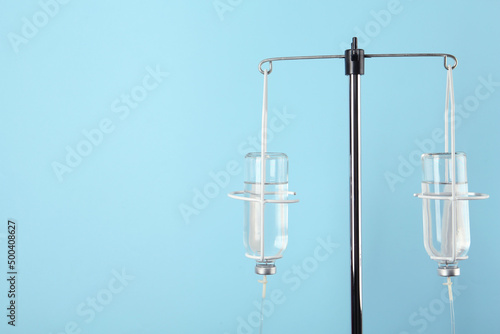 IV infusion set on light blue background. Space for text