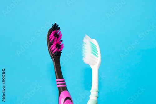 Two toothbrushes on a blue background closeup