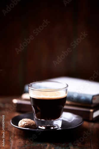Coffee in glass cup on rustic wooden background. Copy space.