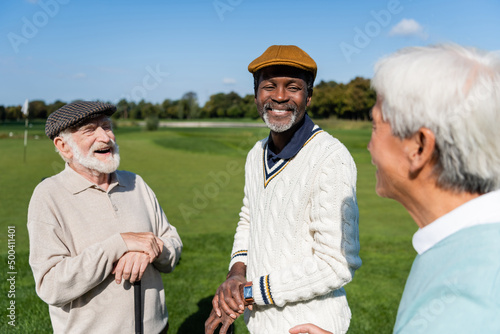 happy and senior multiethnic men looking at blurred asian friend. © LIGHTFIELD STUDIOS