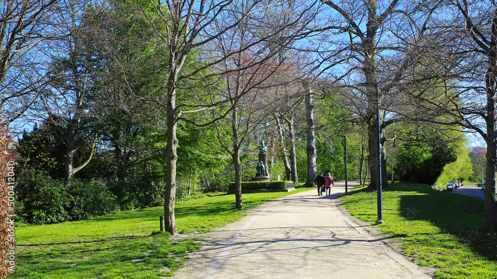 Lier, Belgium - April 9. 2022: View on path through green springtime park along town moat