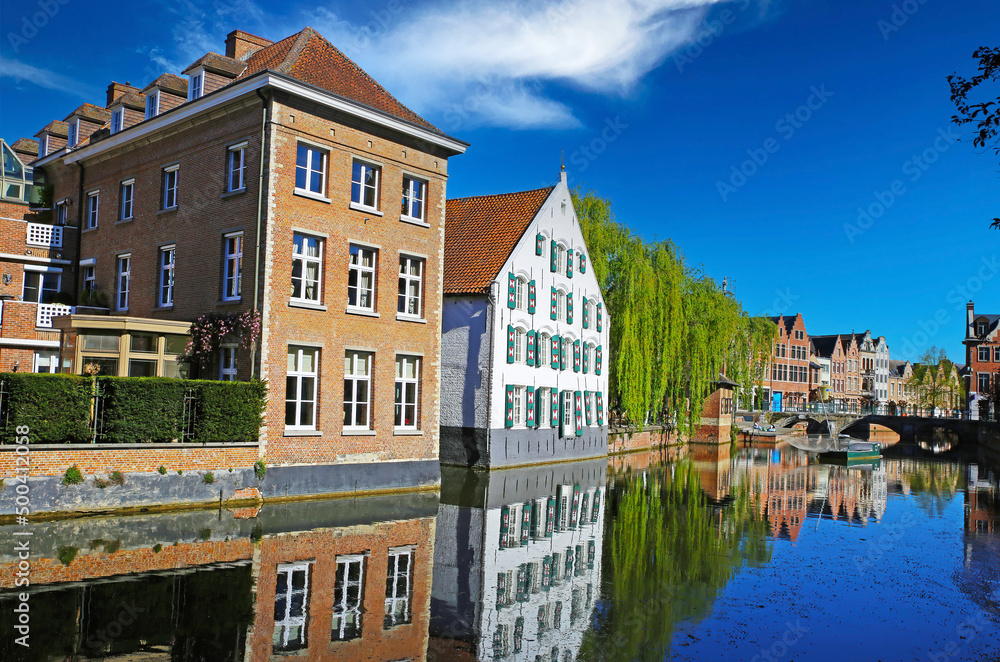 Lier, Belgium - April 9. 2022: View over water town moat on  medieval romantic old cityscape, ancient stone bridge, clear blue sky