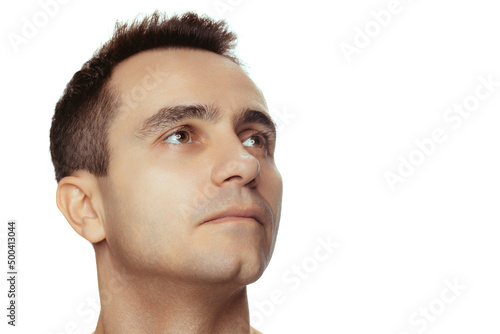 Close-up portrait of young handsome man with clean face, perfect skin, shirtless posing isolated over white studio background