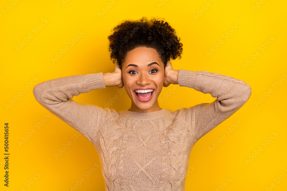 Photo of hooray millennial brunette lady close ears wear sweater isolated on yellow color background Photo of hooray millennial brunette lady close ears wear sweater isolated on yellow color background