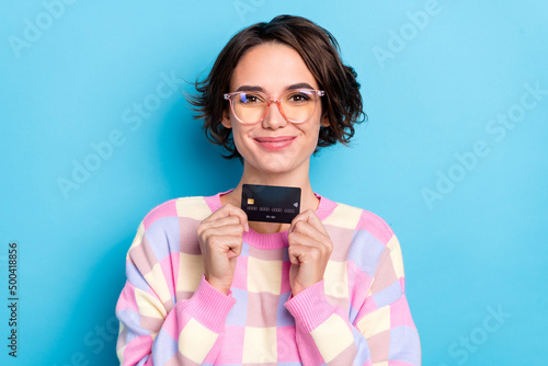 Photo of sweet young brunette lady show card wear eyewear checkered pullover isolated on blue background