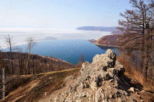 A popular view of the source of the Angara River on Lake Baikal in the village of Listvyanka, Chersky Stone Mountain. Spring landscape, ice on the lake. photo