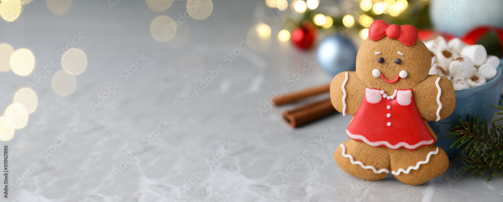 Gingerbread girl on grey marble table, space for text. Banner design