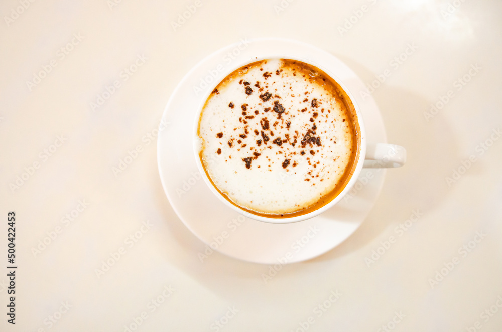 Fototapeta premium Cappuccino coffee on white table, photo taken in studio. Soft focus